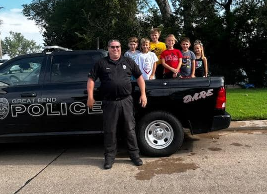 School Resource Officer Millard poses for photo with children in his truck